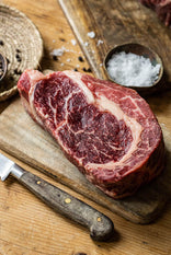 A raw, grass fed beef ribeye sharing steak.